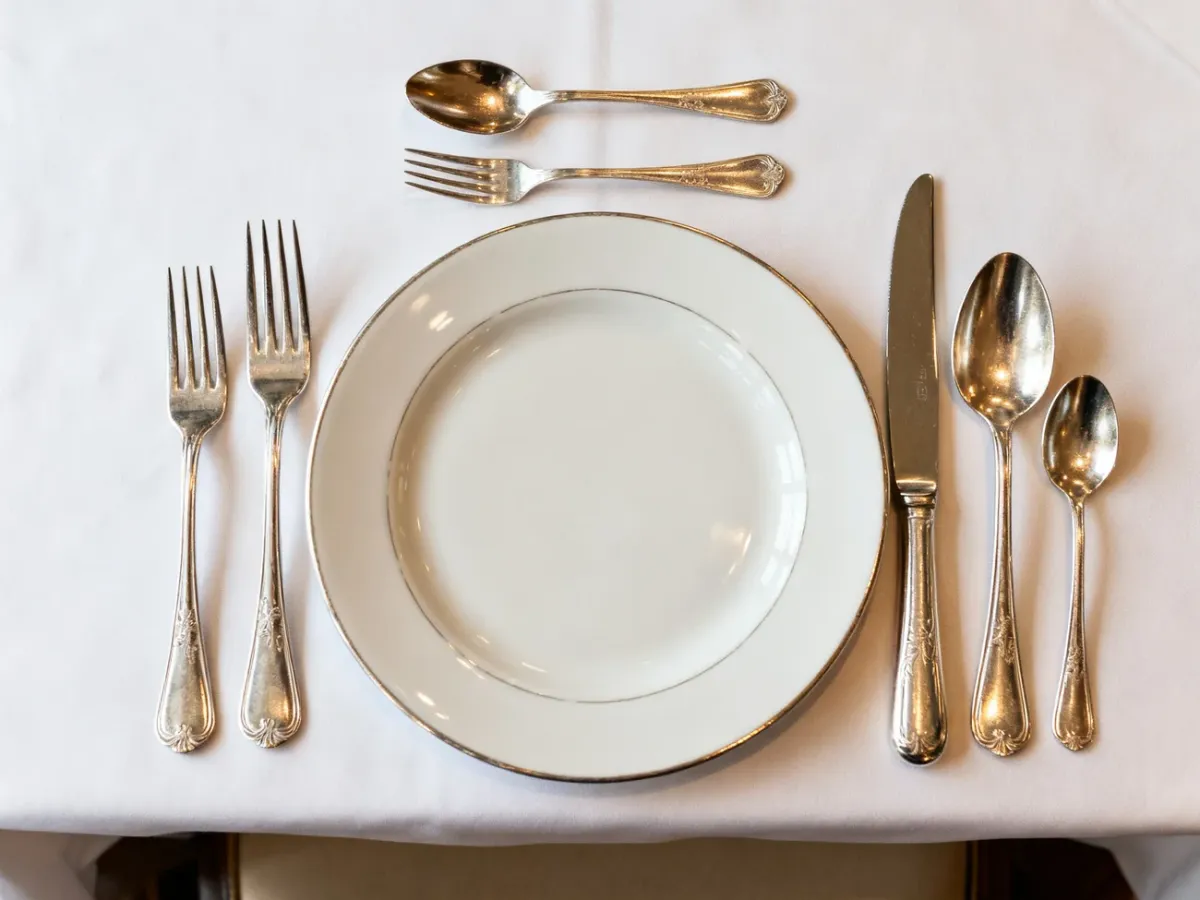 Formal place setting showing the correct positions of forks, knives, spoons, and dessert cutlery